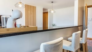 Una cocina moderna con una encimera, un secador de pelo y dos sillas.