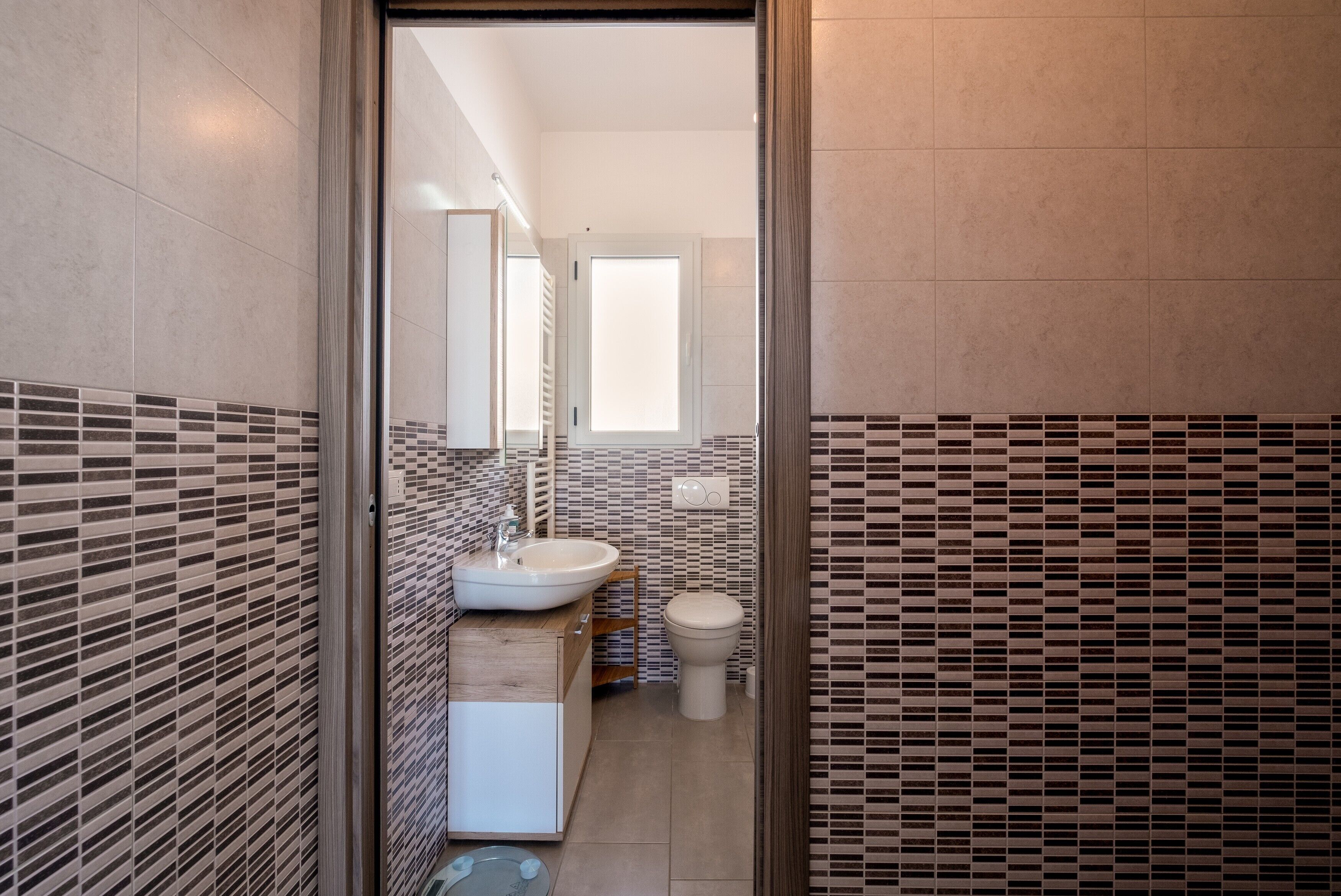 Une salle de bain moderne avec un lavabo, des toilettes et un miroir.