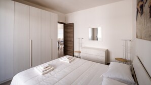 A bedroom with a large bed, a wardrobe, a dresser, and a painting on the wall. - Holiday Home "Vista Mare Marittima di Diso" with Terrace & Wi-Fi (Marittima)