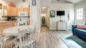 A kitchen with wooden cabinets, a microwave, and a dining table with chairs.