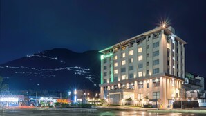 A multi-story Holiday Inn hotel with a modern design, featuring a prominent entrance and a view of a mountain in the background. - Holiday Inn Katra Vaishno Devi by IHG (Reasi)