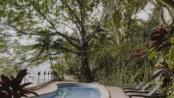 Una piscina circular con borde de azulejos, rodeada por un sendero de ladrillo.