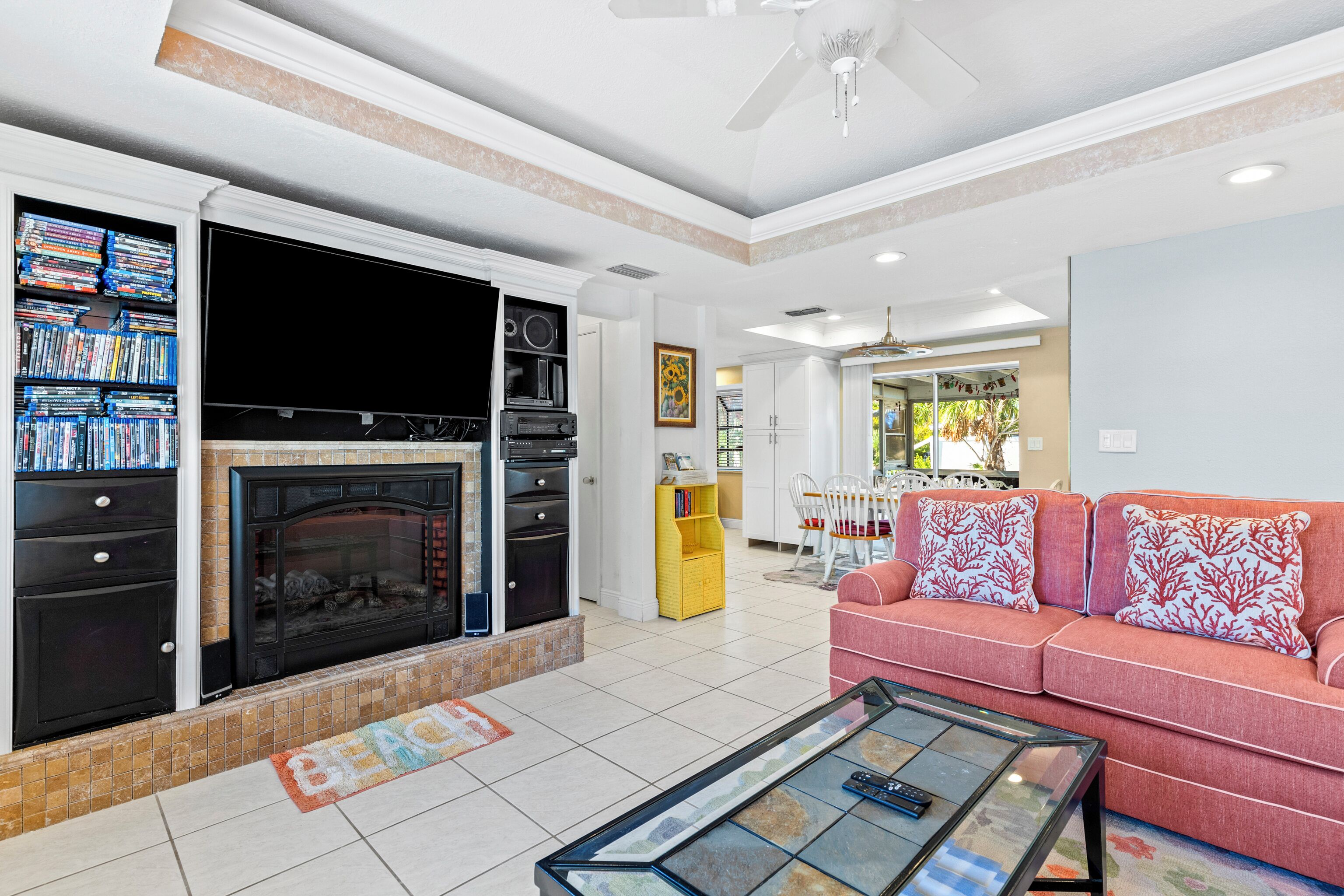 A living room with a fireplace, a sofa, a coffee table, and a television.