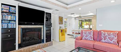 A living room with a fireplace, a sofa, a coffee table, and a television.