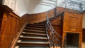 A grand staircase with ornate railings and a polished wooden floor. - Casa Marina Huérfanos (Santiago)
