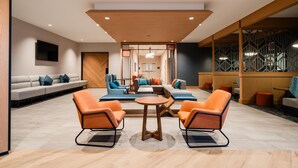 A modern lobby with a seating area, a wooden ceiling, and a patterned wall. - Hyatt House Sacramento Airport - Natomas (Sacramento)