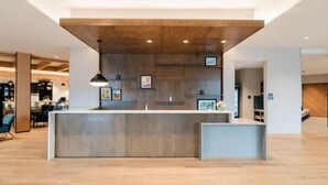 A modern reception area with a wooden ceiling, a counter, and framed artwork on the wall. - Hyatt House Sacramento Airport - Natomas (Sacramento)