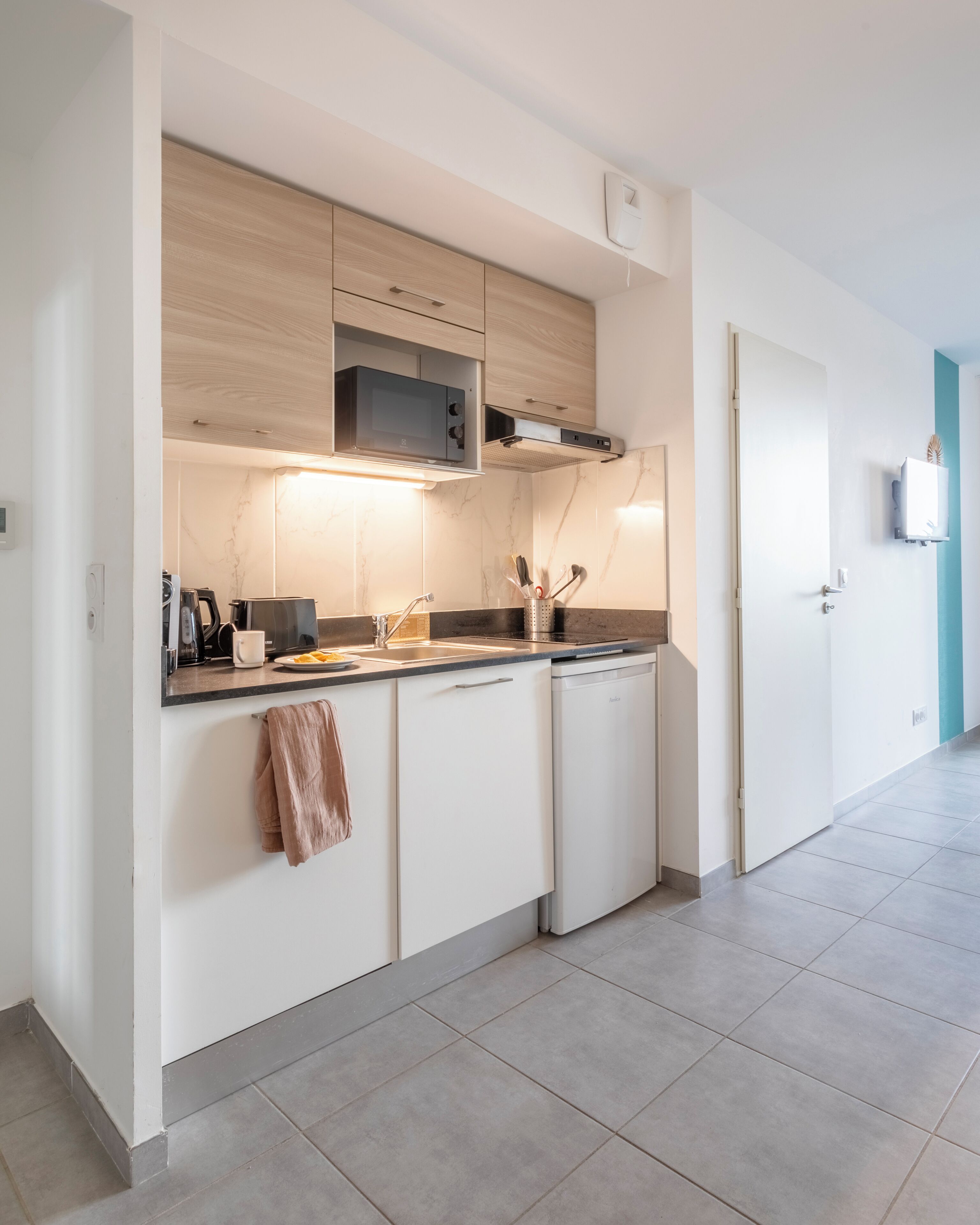 A modern kitchen with white cabinets, a microwave, and a dishwasher.