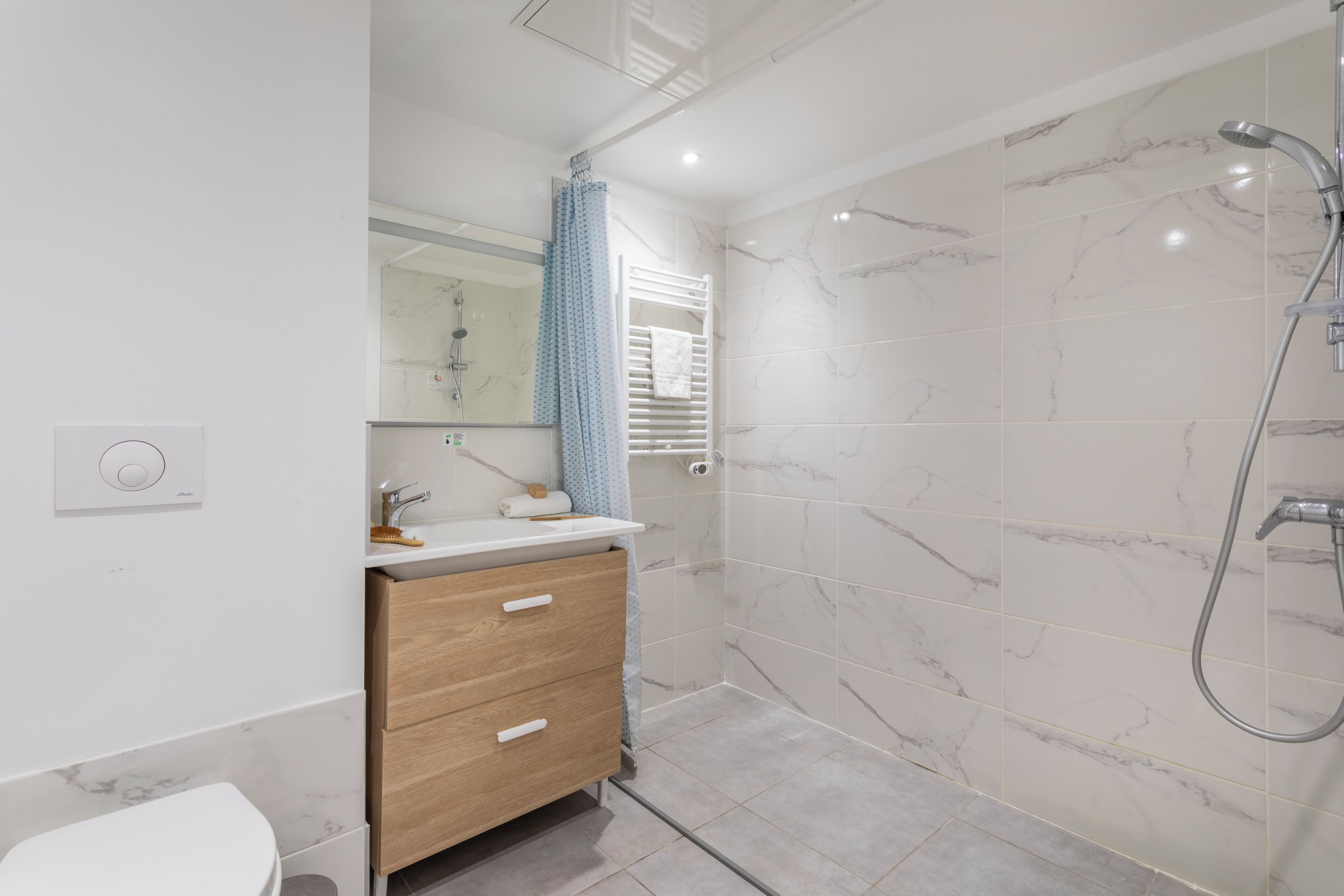 Ein modernes Badezimmer mit Dusche, Toilette und Waschtisch mit Schubladen.