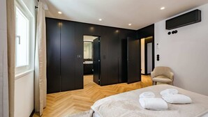 Une chambre à coucher moderne avec un lit, une chaise et un dressing.