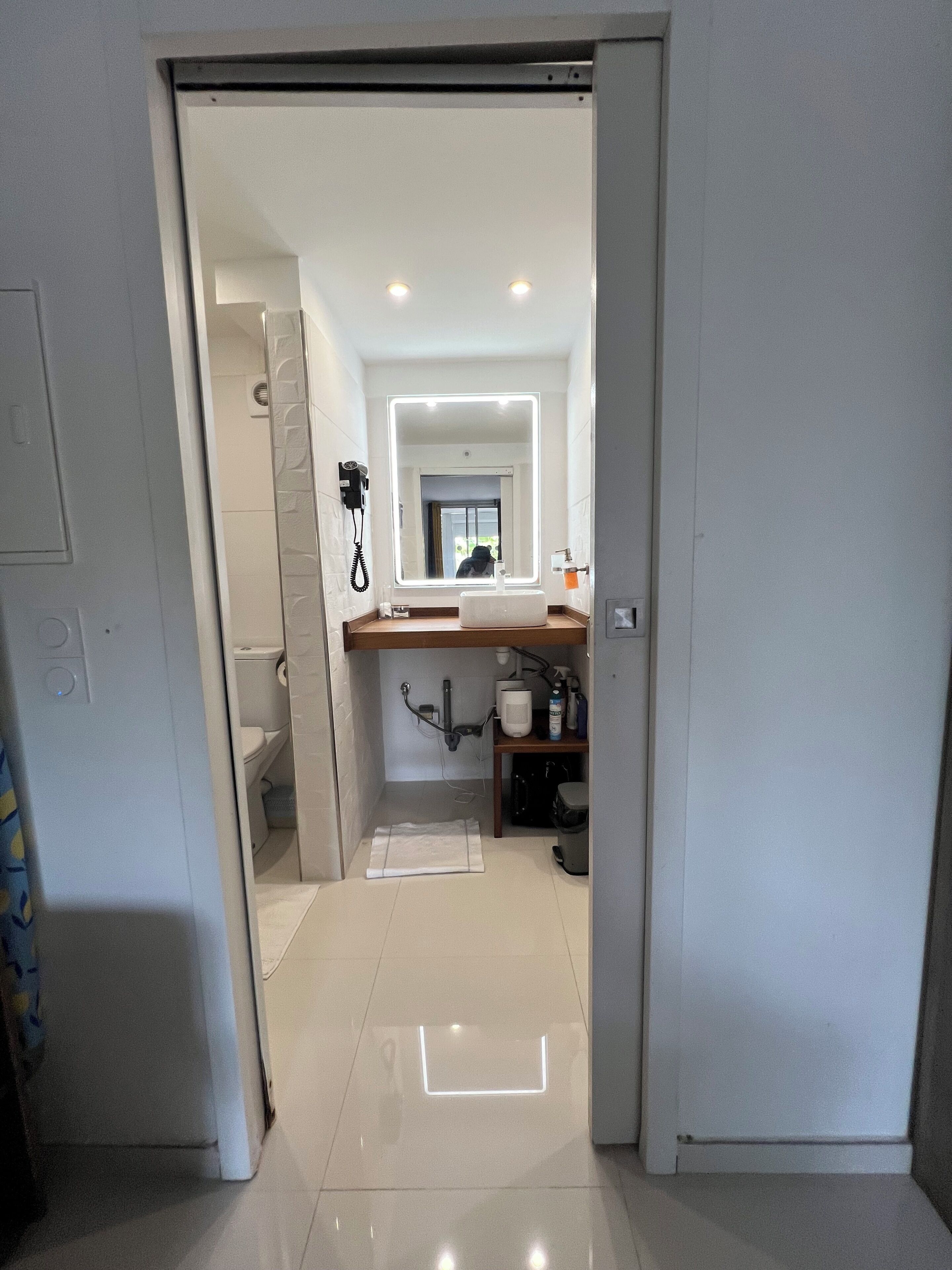 Une salle de bain moderne avec un grand miroir, un lavabo et des toilettes.