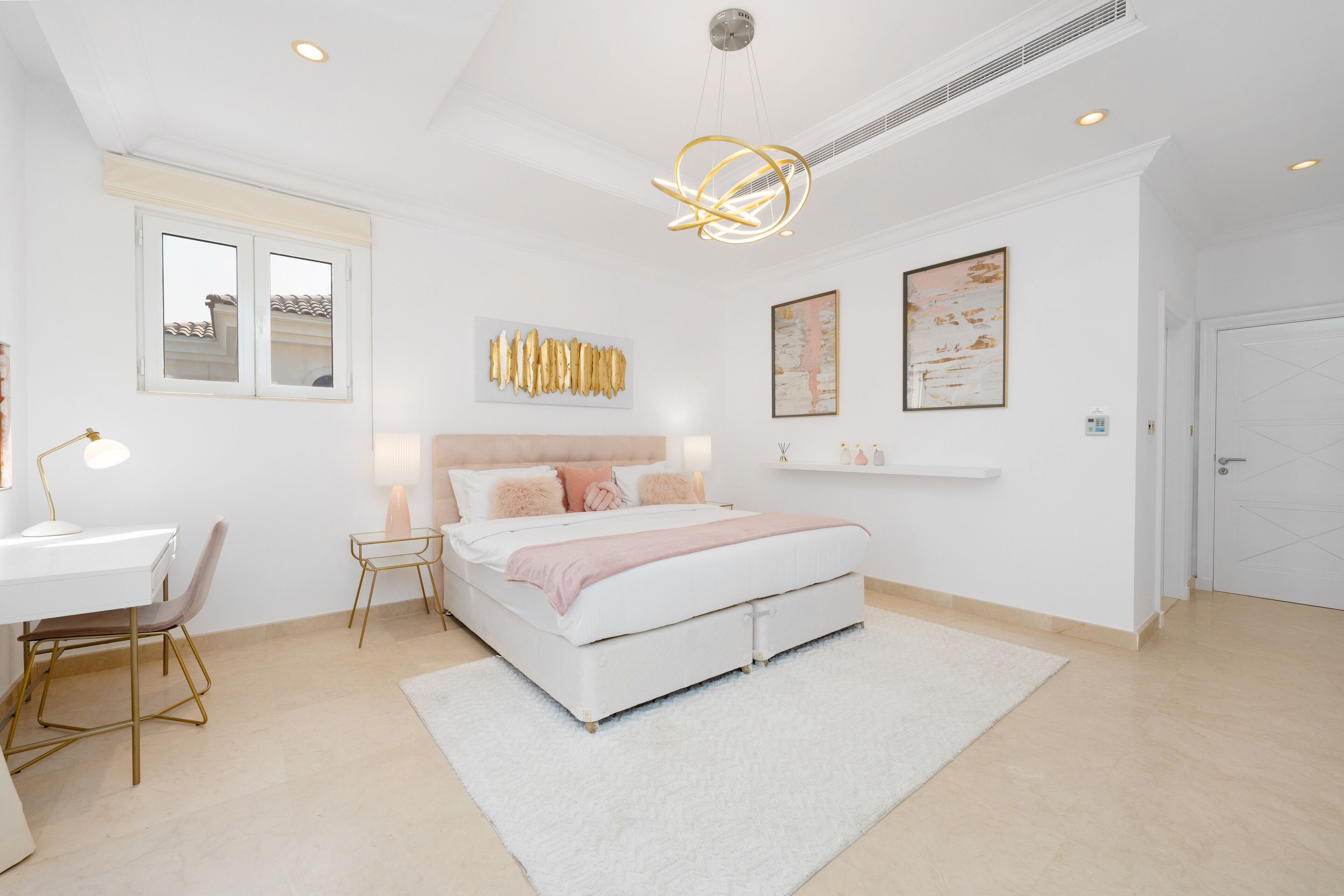 Een slaapkamer met een bed, nachtkastjes, een bureau en een stoel.