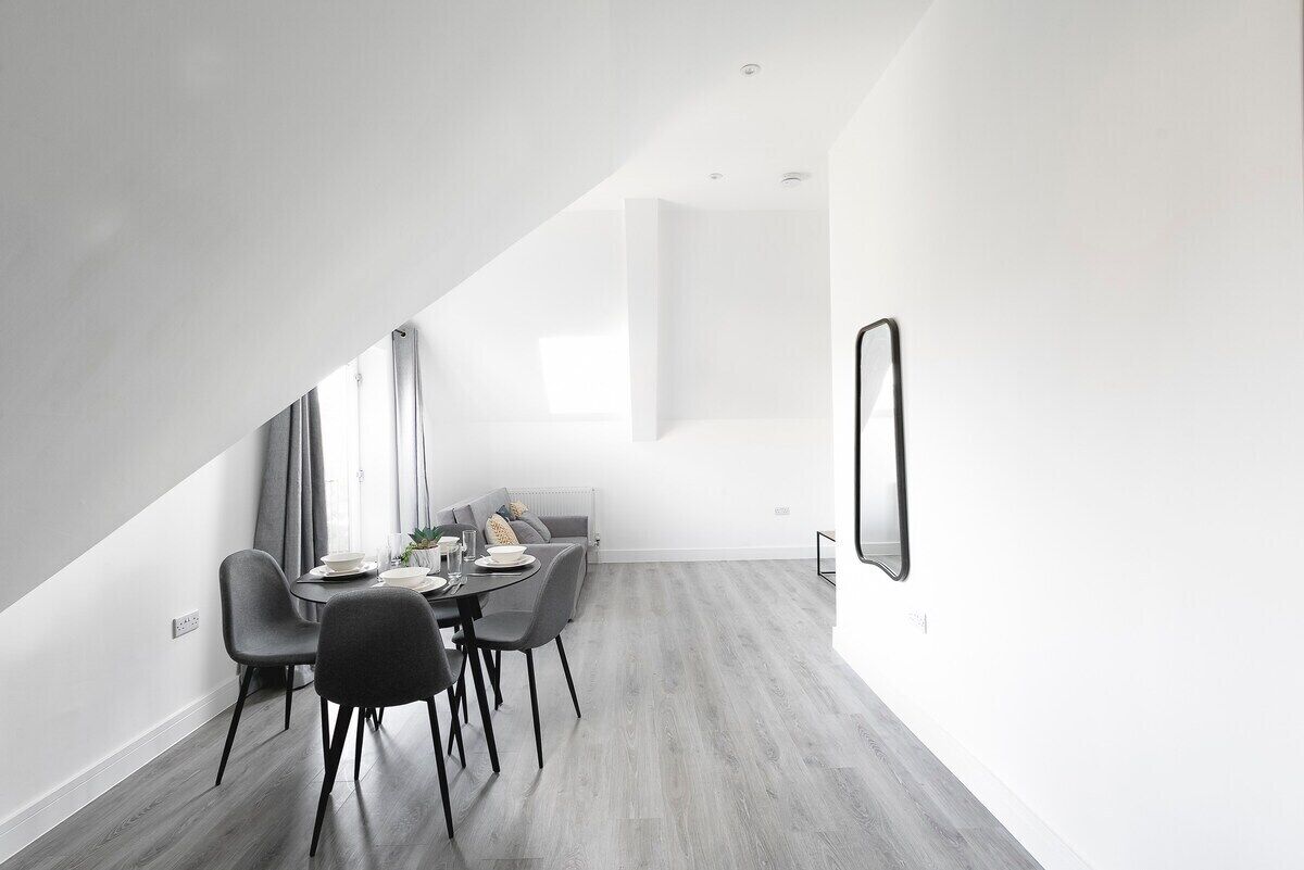 A modern dining area with a high ceiling and a sloped ceiling design.