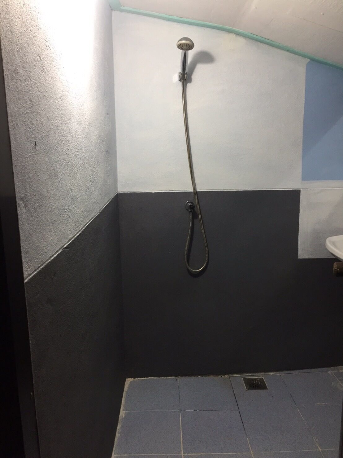 Un baño con ducha, lavamanos y piso de baldosas.