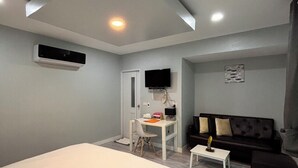 A modern bedroom with a bed, a desk, a sofa, and a TV. - Baansuan Suksangob Farm Stay (Yan Ta Khao)