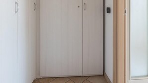 A corner room with a wardrobe, a door, and a tiled floor.