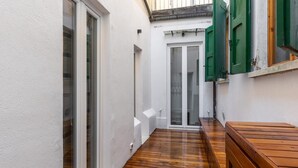 A narrow corridor with wooden flooring, white walls, and a sliding glass door. - Appartamento al Ghetto Ebraico by Wonderful Italy (Bologna)