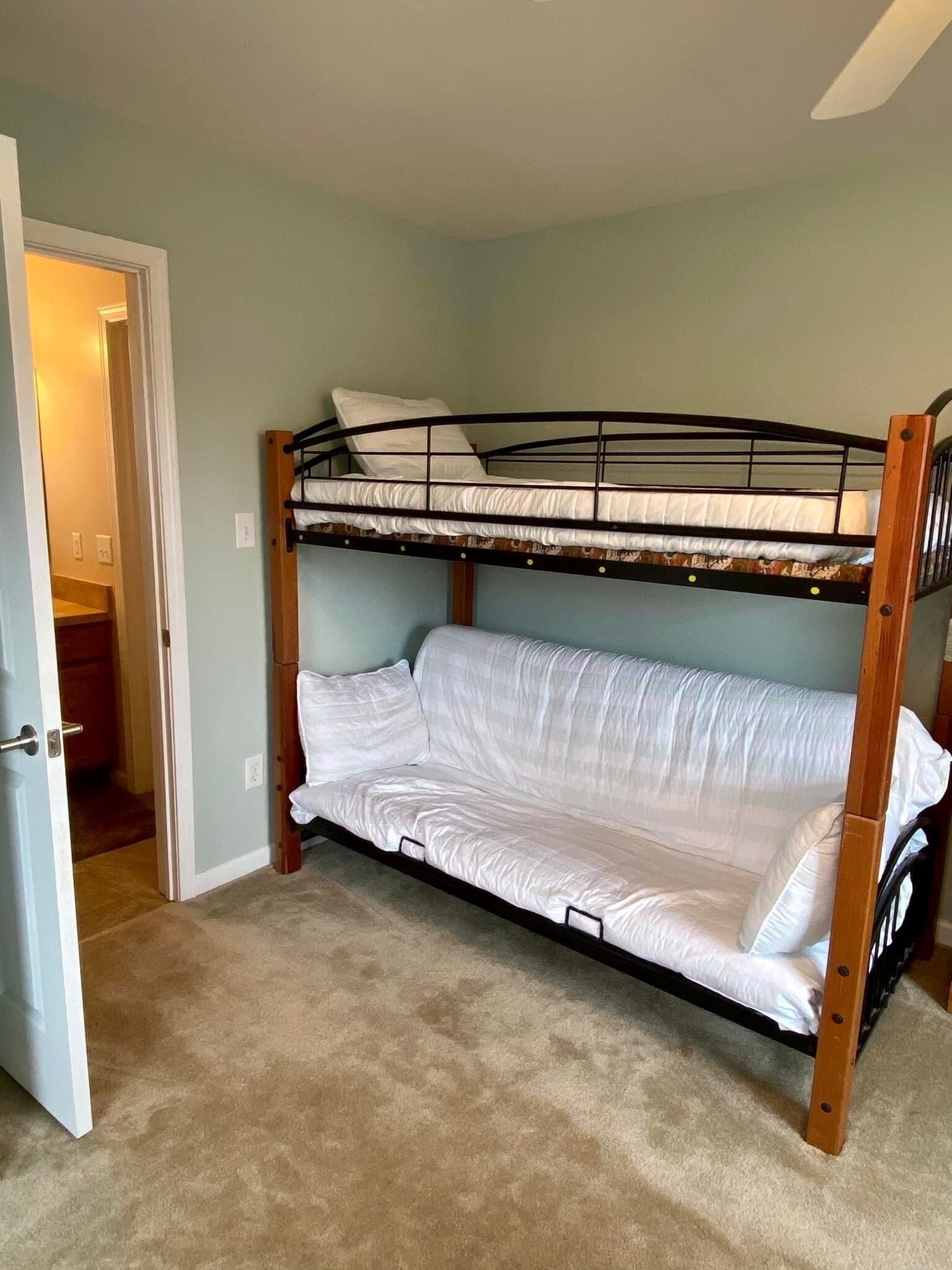 A bunk bed in a room with light blue walls and carpet.