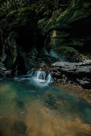 A natural rock formation with a small waterfall.