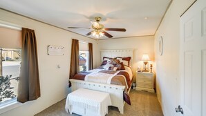 A bedroom with a bed, bedside table, lamp, and a ceiling fan. - Pecos Vacation Rental Near Rodeo Arena! (Pecos)