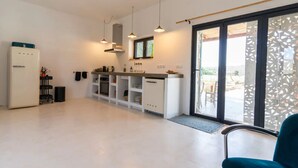 Une cuisine moderne dotée d’un four encastré, d’un réfrigérateur et de luminaires suspendus.