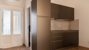 A compact kitchen with a built-in oven, a sink, and a microwave. - Cozy Studio in the heart of Navigli (Milano)