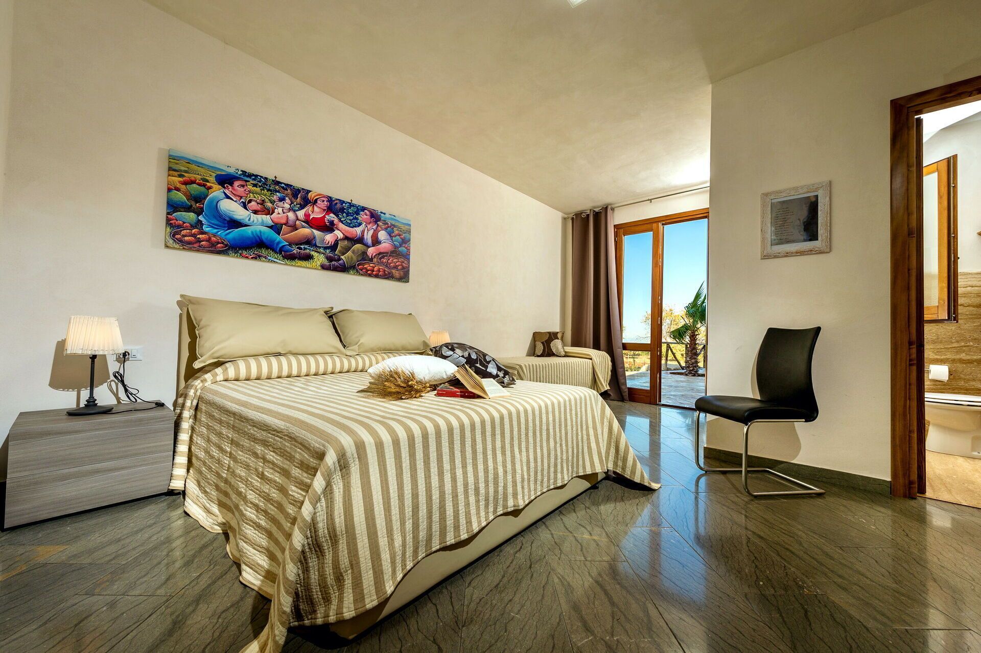 Ein Hotelzimmer mit einem großen Bett, einem Sessel, einem Schreibtisch und einem Gemälde an der Wand.