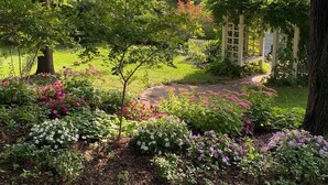A garden with a pathway leading to a house.