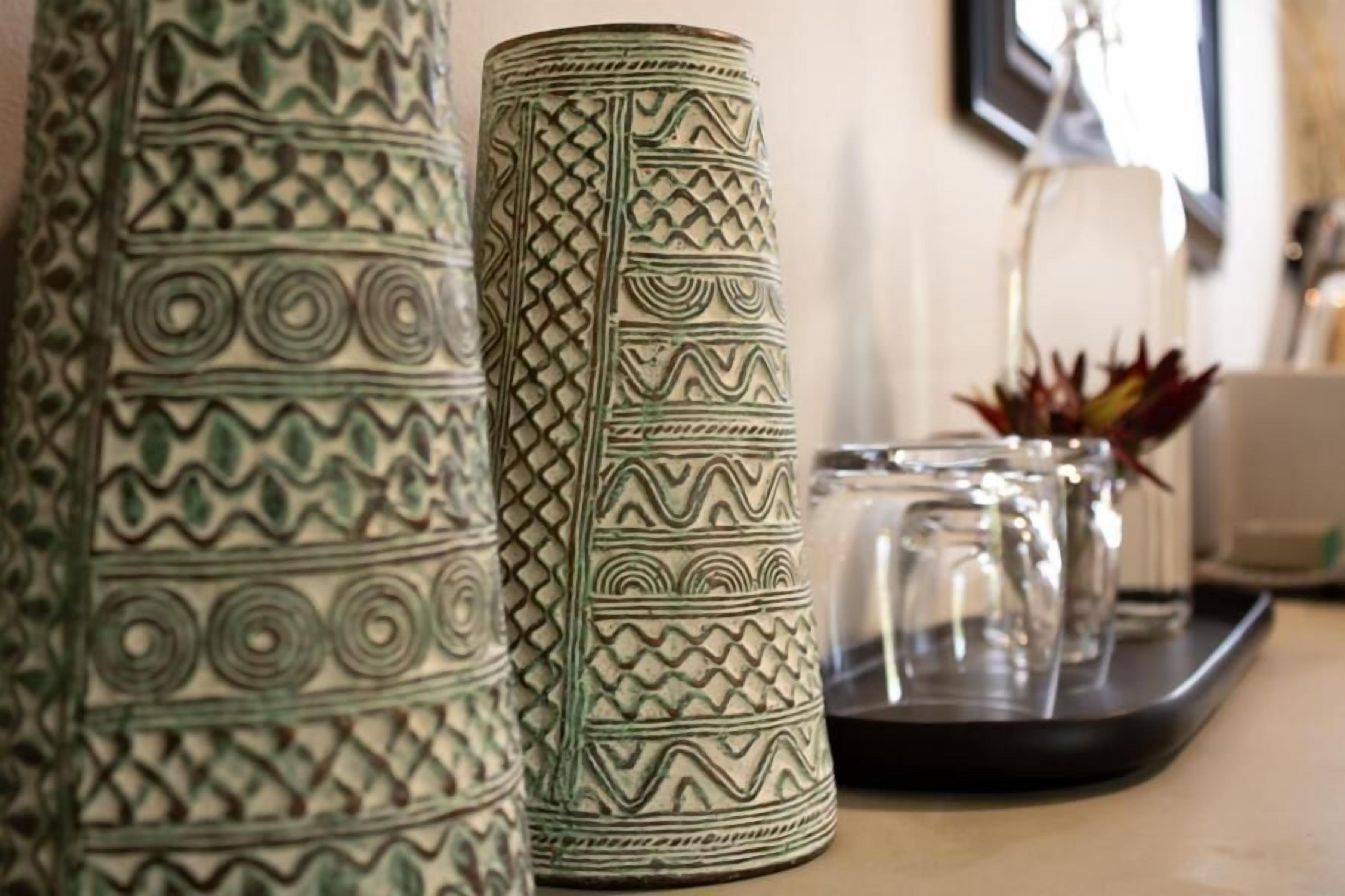 Two decorative vases with intricate patterns on a countertop.