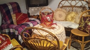 A living room with a television, wicker furniture, and various decorative items. - VERY LARGE APARTMENT 10 MINUTES FROM THE SEA EQUIPPED WITH KITCHEN, LIVING ROOM AND, (San Ferdinando di Puglia)