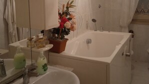 A bathroom with a bathtub, a sink, a mirror, and a potted plant. - VERY LARGE APARTMENT 10 MINUTES FROM THE SEA EQUIPPED WITH KITCHEN, LIVING ROOM AND, (San Ferdinando di Puglia)