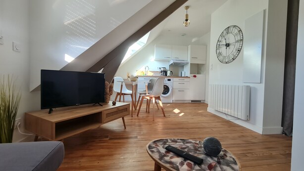 Eine moderne Wohnung mit Schlafgalerie, Flachbildfernseher, Essbereich und Küche.