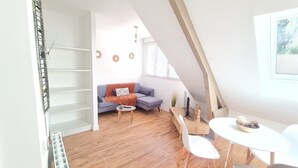 Ein gemütliches Wohnzimmer mit einer Couch, einem Couchtisch und einem Essbereich mit Stühlen und einem Tisch.