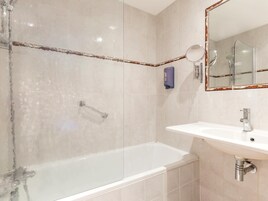 Un baño moderno con bañera, lavabo y ducha.