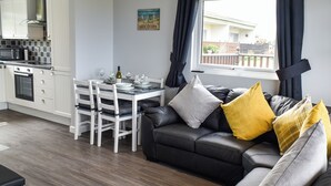 A modern kitchen with white cabinets and a dining area with a table set for four.