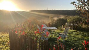 A garden with a wooden fence, a metal table, and a bench. - Gardener's Cottage with Stunning Views (Rowlands Gill)