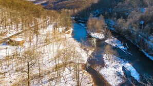 A river flowing through a forested valley with snow on the ground. - Riverside Suite*HotTub*WiFi*Steps to the River (Elkins)