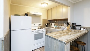 A kitchen with a wooden countertop, white appliances, and wooden cabinets. - Riverside Suite*HotTub*WiFi*Steps to the River (Elkins)