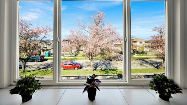 A large window with a view of a residential area, including houses and parked cars. - Newly Renovated Home Heart of Vancouver Near YVR, Skytrain, Downtown (AC) (Vancouver)