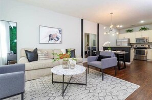 Relax in this stylish living space with a sofa set, coffee table, and armchairs.