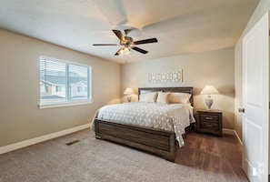Cozy retreat with a large bed, bedside tables, and a ceiling fan.