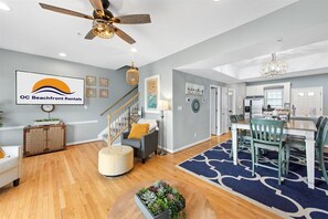 Relax in this inviting living area with a dining table for four, a staircase, and a cozy ottoman.