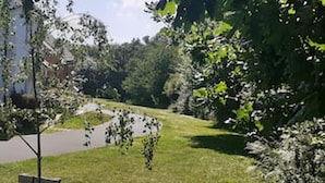 Ein Park mit befestigtem Weg, Rasenflächen und Bäumen.
