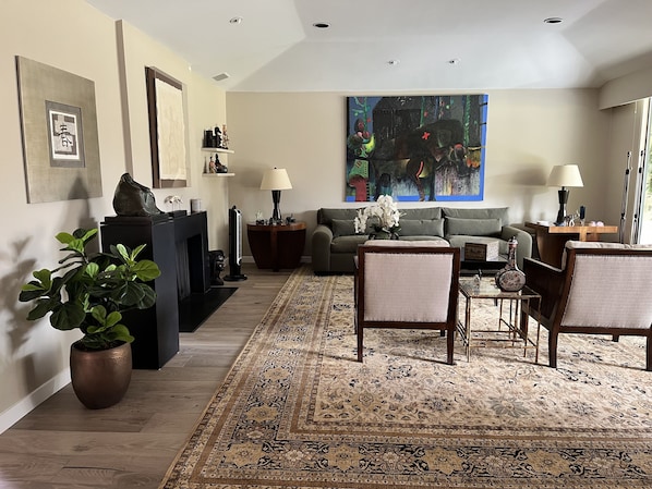 A living room with a fireplace, a sofa, a coffee table, and a rug.