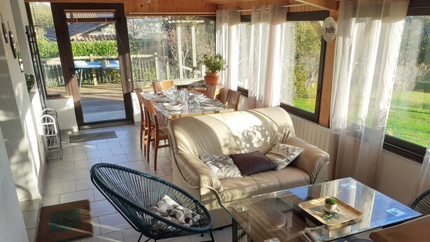 A cozy living area with a sofa, two chairs, a glass coffee table, and a dining table set for two. - Country house close to town: 1 star (SARLAT)