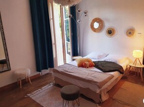 Cozy retreat with a large bed, round table, and wall-mounted mirror.