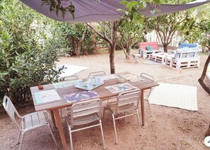 Relax in this serene outdoor seating area, complete with a table and comfortable chairs.