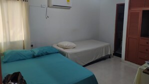 A small, single-room accommodation with a bed, a wardrobe, and an air conditioning unit. - samalinda (Santa Marta)