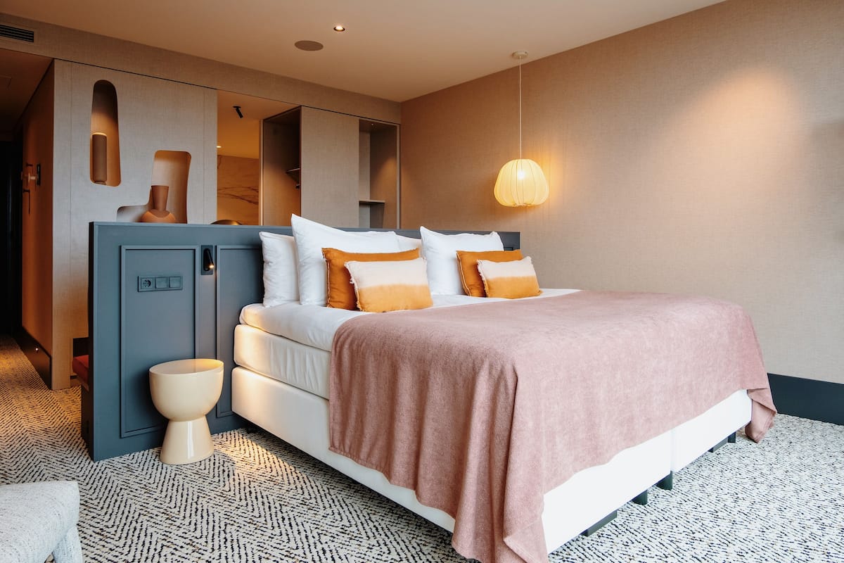 Une chambre à coucher moderne, avec un lit, des tables de chevet et une armoire intégrée.