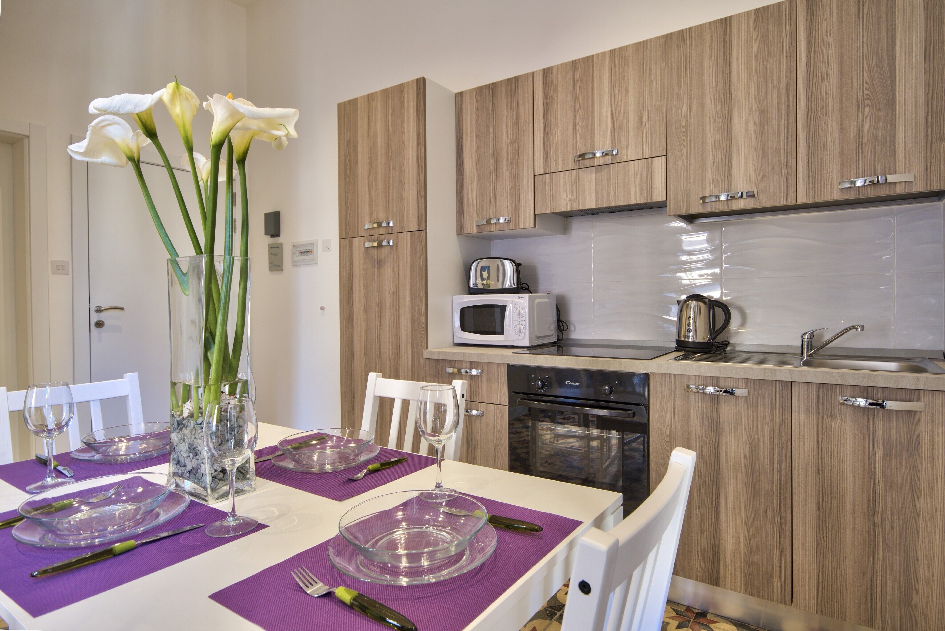 A modern kitchen with wooden cabinets, a microwave, and an oven.